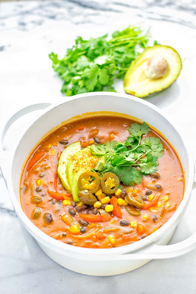 This Spicy Garlic Enchilada Soup is made in one pot, insanely delicious and super easy to make. Naturally vegan, gluten free and amazing for dinner, lunch, meal prep and work lunch. Try it now you won't believe how easy it is! #vegan #glutenfree #dairyfree # vegetarian #enchilada #soup #dinner #lunch #mealprep #worklunchideas #onepotmeals #enchiladasoup #contentednesscooking 