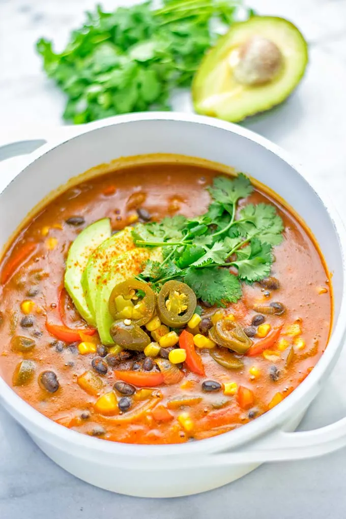 This Spicy Garlic Enchilada Soup is made in one pot, insanely delicious and super easy to make. Naturally vegan, gluten free and amazing for dinner, lunch, meal prep and work lunch. Try it now you won't believe how easy it is! #vegan #glutenfree #dairyfree # vegetarian #enchilada #soup #dinner #lunch #mealprep #worklunchideas #onepotmeals #enchiladasoup #contentednesscooking 