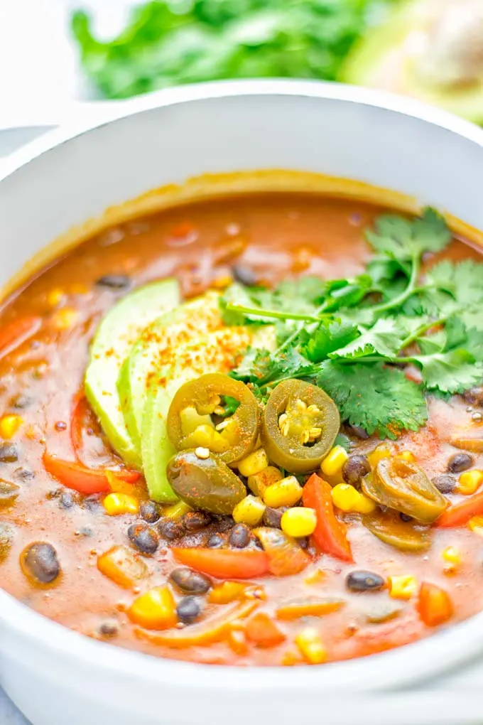 This Spicy Garlic Enchilada Soup is made in one pot, insanely delicious and super easy to make. Naturally vegan, gluten free and amazing for dinner, lunch, meal prep and work lunch. Try it now you won't believe how easy it is! #vegan #glutenfree #dairyfree # vegetarian #enchilada #soup #dinner #lunch #mealprep #worklunchideas #onepotmeals #enchiladasoup #contentednesscooking 