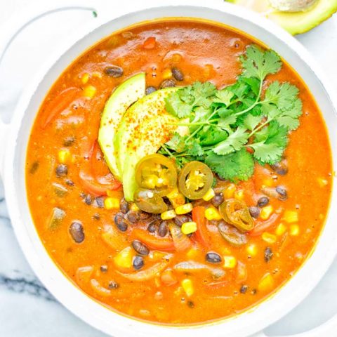 This Spicy Garlic Enchilada Soup is made in one pot, insanely delicious and super easy to make. Naturally vegan, gluten free and amazing for dinner, lunch, meal prep and work lunch. Try it now you won't believe how easy it is! #vegan #glutenfree #dairyfree # vegetarian #enchilada #soup #dinner #lunch #mealprep #worklunchideas #onepotmeals #enchiladasoup #contentednesscooking