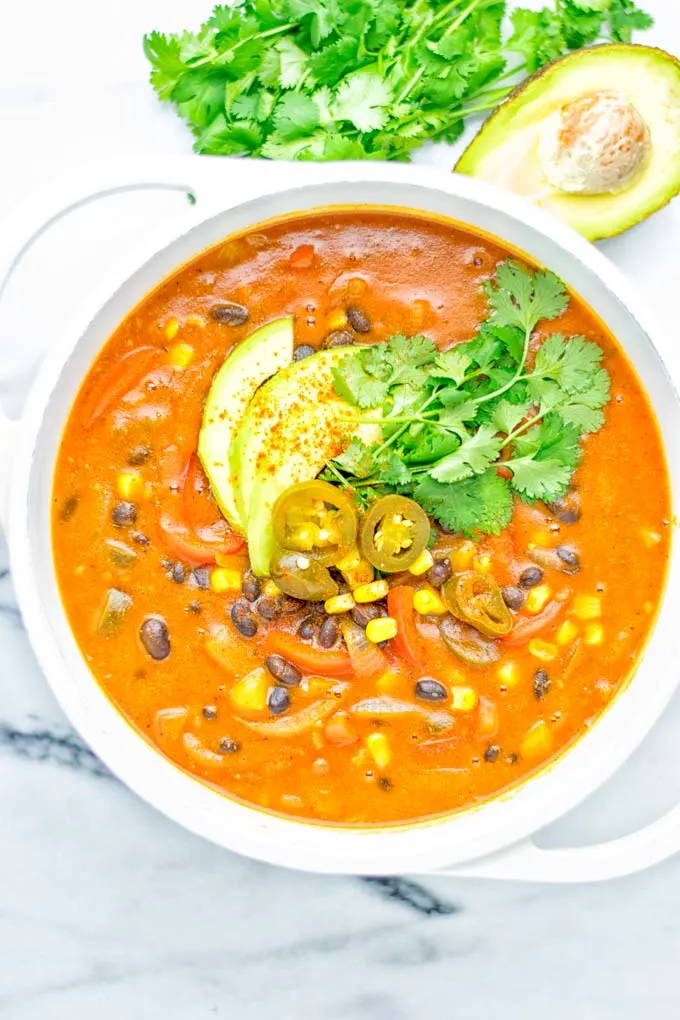 This Spicy Garlic Enchilada Soup is made in one pot, insanely delicious and super easy to make. Naturally vegan, gluten free and amazing for dinner, lunch, meal prep and work lunch. Try it now you won't believe how easy it is! #vegan #glutenfree #dairyfree # vegetarian #enchilada #soup #dinner #lunch #mealprep #worklunchideas #onepotmeals #enchiladasoup #contentednesscooking 