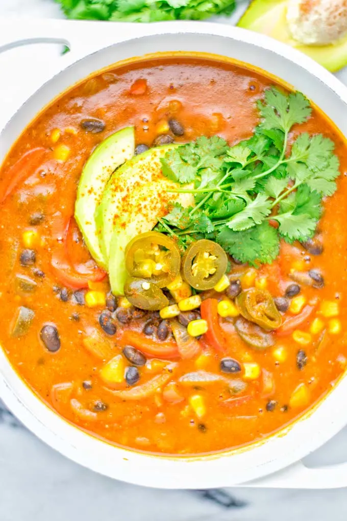 This Spicy Garlic Enchilada Soup is made in one pot, insanely delicious and super easy to make. Naturally vegan, gluten free and amazing for dinner, lunch, meal prep and work lunch. Try it now you won't believe how easy it is! #vegan #glutenfree #dairyfree # vegetarian #enchilada #soup #dinner #lunch #mealprep #worklunchideas #onepotmeals #enchiladasoup #contentednesscooking 