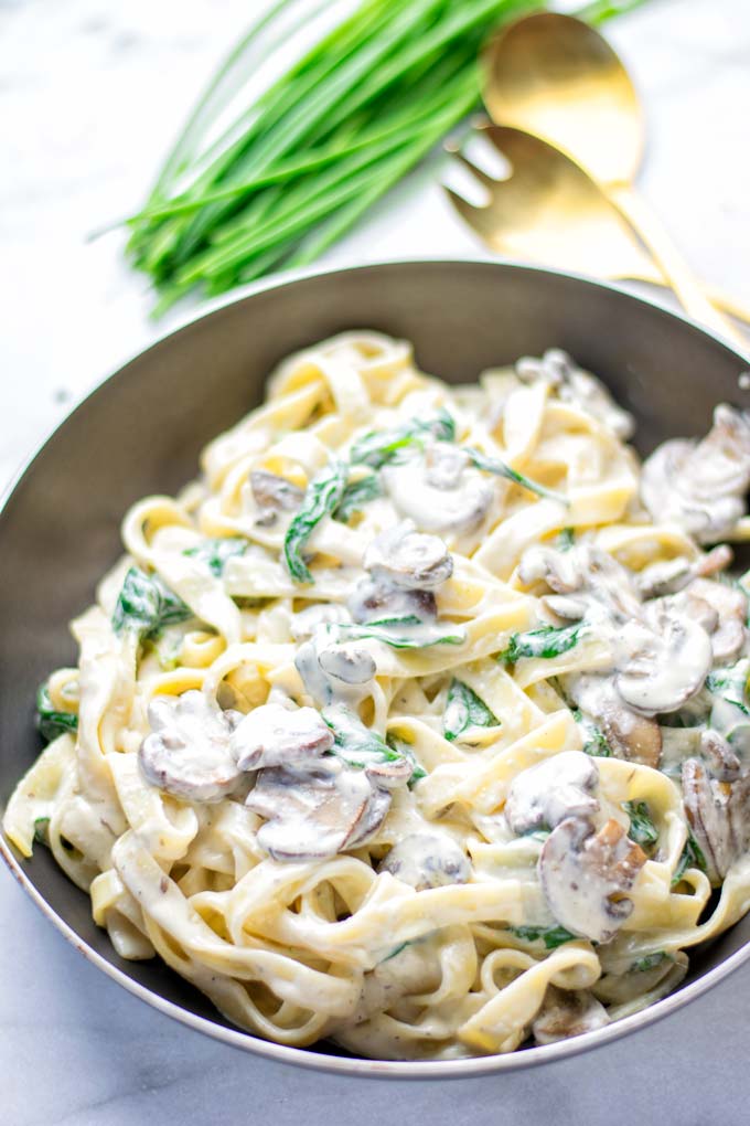 Super creamy and easy to make: Spinach Mushroom Fettuccine Alfredo entirely vegan, gluten free and the ultimate comfort food for dinner, lunch, meal preparation that the whole family will love. If you’re looking for a delicious fettuccine Alfredo recipe try it now, it’s a keeper. #vegan #glutenfree #dairyfree #vegetarian #contentednesscooking #dinner #lunch #mealprep #worklunchideas #fettuccinealfredo #spinachrecipes #mushroomrecipes #familydinnerideas #fettuccinerecipes #easy20minutemeals