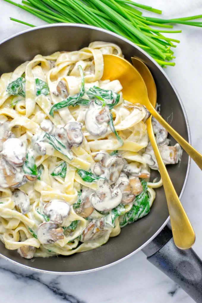 Super creamy and easy to make: Spinach Mushroom Fettuccine Alfredo entirely vegan, gluten free and the ultimate comfort food for dinner, lunch, meal preparation that the whole family will love. If you’re looking for a delicious fettuccine Alfredo recipe try it now, it’s a keeper. #vegan #glutenfree #dairyfree #vegetarian #contentednesscooking #dinner #lunch #mealprep #worklunchideas #fettuccinealfredo #spinachrecipes #mushroomrecipes #familydinnerideas #fettuccinerecipes #easy20minutemeals