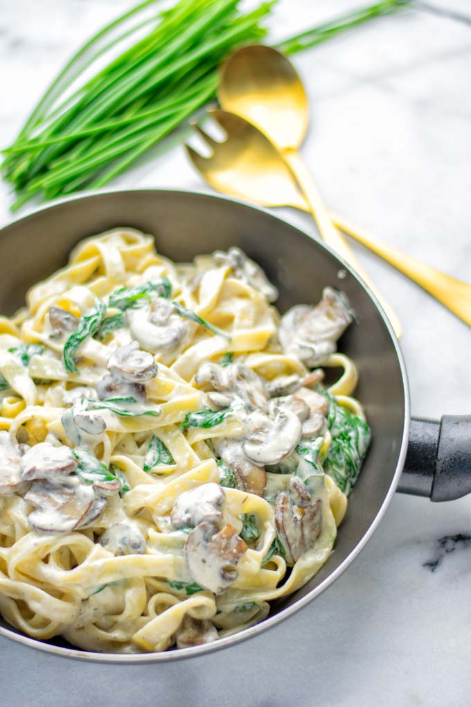 Super creamy and easy to make: Spinach Mushroom Fettuccine Alfredo entirely vegan, gluten free and the ultimate comfort food for dinner, lunch, meal preparation that the whole family will love. If you’re looking for a delicious fettuccine Alfredo recipe try it now, it’s a keeper. #vegan #glutenfree #dairyfree #vegetarian #contentednesscooking #dinner #lunch #mealprep #worklunchideas #fettuccinealfredo #spinachrecipes #mushroomrecipes #familydinnerideas #fettuccinerecipes #easy20minutemeals