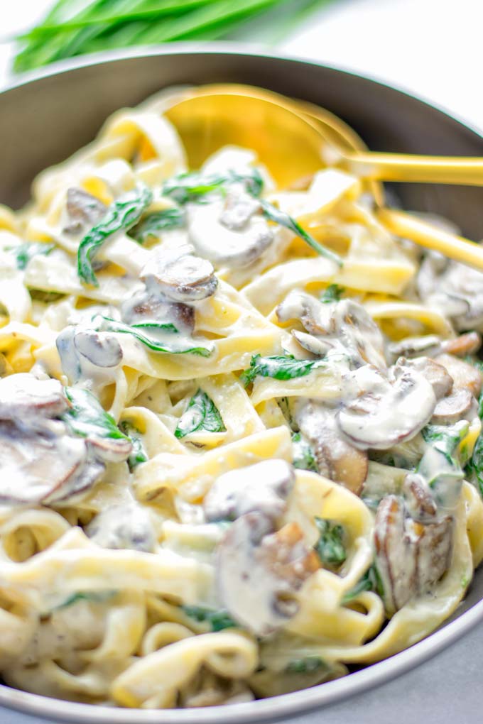 Super creamy and easy to make: Spinach Mushroom Fettuccine Alfredo entirely vegan, gluten free and the ultimate comfort food for dinner, lunch, meal preparation that the whole family will love. If you’re looking for a delicious fettuccine Alfredo recipe try it now, it’s a keeper. #vegan #glutenfree #dairyfree #vegetarian #contentednesscooking #dinner #lunch #mealprep #worklunchideas #fettuccinealfredo #spinachrecipes #mushroomrecipes #familydinnerideas #fettuccinerecipes #easy20minutemeals