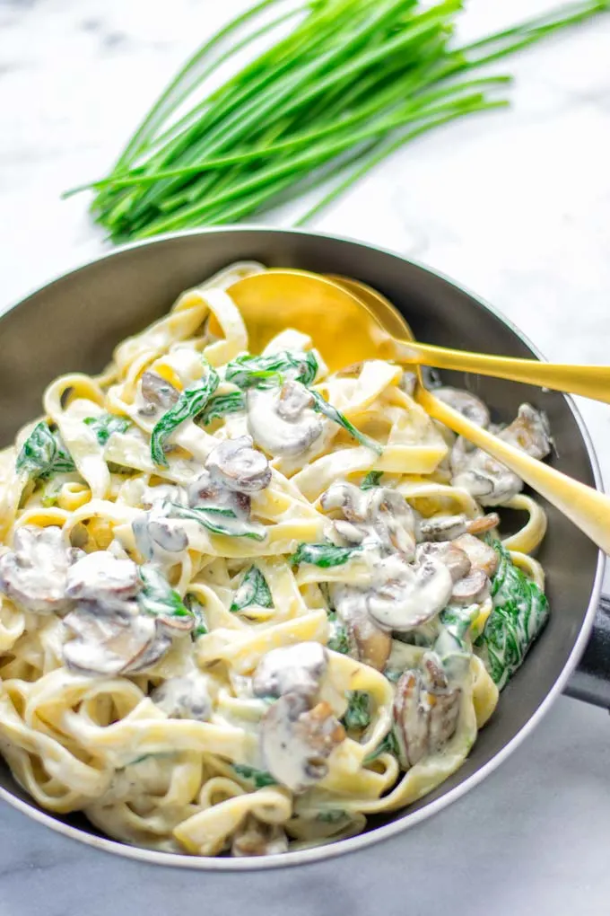 Super creamy and easy to make: Spinach Mushroom Fettuccine Alfredo entirely vegan, gluten free and the ultimate comfort food for dinner, lunch, meal preparation that the whole family will love. If you’re looking for a delicious fettuccine Alfredo recipe try it now, it’s a keeper. #vegan #glutenfree #dairyfree #vegetarian #contentednesscooking #dinner #lunch #mealprep #worklunchideas #fettuccinealfredo #spinachrecipes #mushroomrecipes #familydinnerideas #fettuccinerecipes #easy20minutemeals