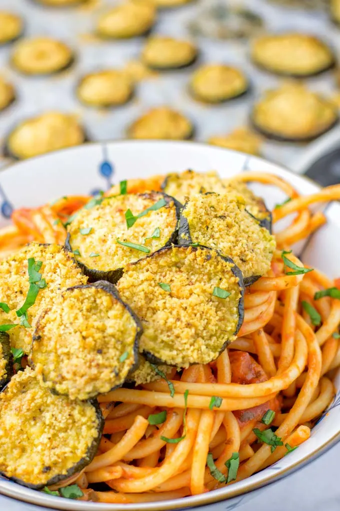 This Baked Zucchini Parmesan is entirely vegan, gluten free and will be a family favorite. Serve it with pasta, dips, as appetizer, dinner, lunches, meal preparation, or work lunch. Sprinkled with the best dairy free parmesan cheese that makes all the difference. Try it now. #vegan #dairyfree #vegetarian #contentednesscooking #dinner #lunch #mealprep #worklunchideas #zucchiniparmesan #zucchiniparmesanbaked #zucchiniparmesancrisps #comfortfood #kidfriendlydinners #familydinnerideas 