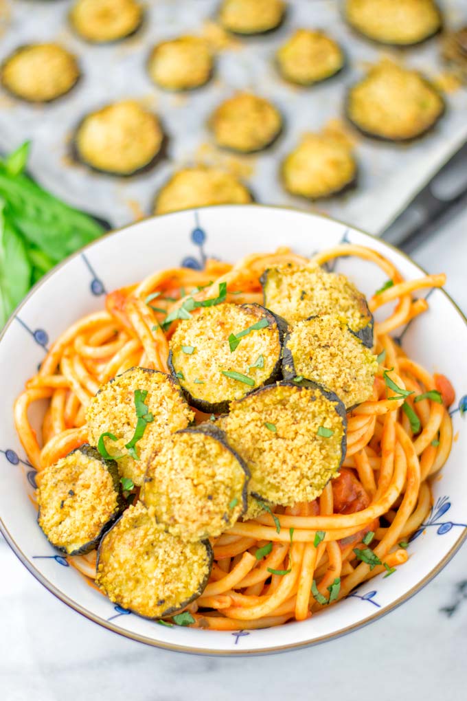 This Baked Zucchini Parmesan is entirely vegan, gluten free and will be a family favorite. Serve it with pasta, dips, as appetizer, dinner, lunches, meal preparation, or work lunch. Sprinkled with the best dairy free parmesan cheese that makes all the difference. Try it now. #vegan #dairyfree #vegetarian #contentednesscooking #dinner #lunch #mealprep #worklunchideas #zucchiniparmesan #zucchiniparmesanbaked #zucchiniparmesancrisps #comfortfood #kidfriendlydinners #familydinnerideas 