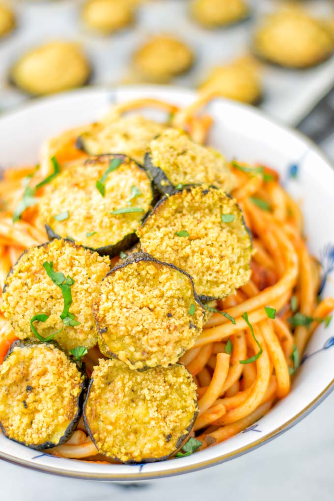 This Baked Zucchini Parmesan is entirely vegan, gluten free and will be a family favorite. Serve it with pasta, dips, as appetizer, dinner, lunches, meal preparation, or work lunch. Sprinkled with the best dairy free parmesan cheese that makes all the difference. Try it now. #vegan #dairyfree #vegetarian #contentednesscooking #dinner #lunch #mealprep #worklunchideas #zucchiniparmesan #zucchiniparmesanbaked #zucchiniparmesancrisps #comfortfood #kidfriendlydinners #familydinnerideas 