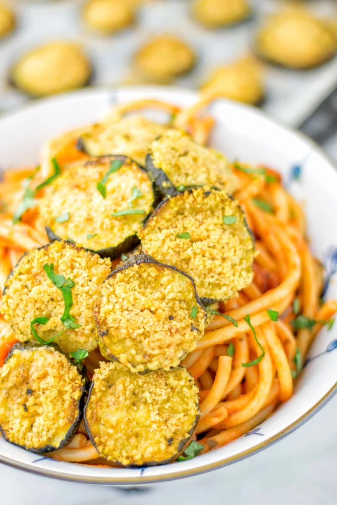 This Baked Zucchini Parmesan is entirely vegan, gluten free and will be a family favorite. Serve it with pasta, dips, as appetizer, dinner, lunches, meal preparation, or work lunch. Sprinkled with the best dairy free parmesan cheese that makes all the difference. Try it now. #vegan #dairyfree #vegetarian #contentednesscooking #dinner #lunch #mealprep #worklunchideas #zucchiniparmesan #zucchiniparmesanbaked #zucchiniparmesancrisps #comfortfood #kidfriendlydinners #familydinnerideas 