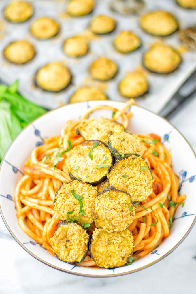 This Baked Zucchini Parmesan is entirely vegan, gluten free and will be a family favorite. Serve it with pasta, dips, as appetizer, dinner, lunches, meal preparation, or work lunch. Sprinkled with the best dairy free parmesan cheese that makes all the difference. Try it now. #vegan #dairyfree #vegetarian #contentednesscooking #dinner #lunch #mealprep #worklunchideas #zucchiniparmesan #zucchiniparmesanbaked #zucchiniparmesancrisps #comfortfood #kidfriendlydinners #familydinnerideas 