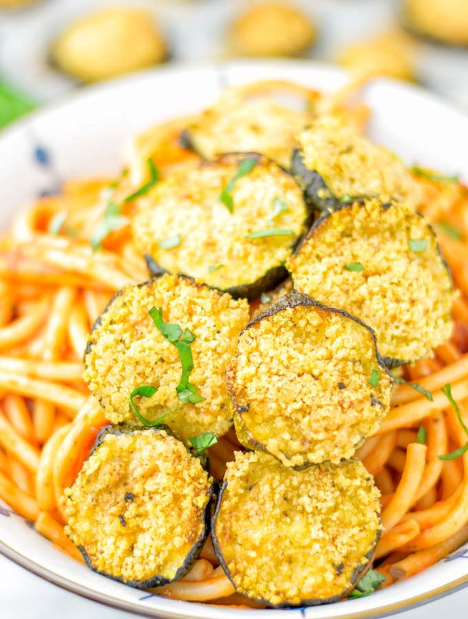 This Baked Zucchini Parmesan is entirely vegan, gluten free and will be a family favorite. Serve it with pasta, dips, as appetizer, dinner, lunches, meal preparation, or work lunch. Sprinkled with the best dairy free parmesan cheese that makes all the difference. Try it now. #vegan #dairyfree #vegetarian #contentednesscooking #dinner #lunch #mealprep #worklunchideas #zucchiniparmesan #zucchiniparmesanbaked #zucchiniparmesancrisps #comfortfood #kidfriendlydinners #familydinnerideas