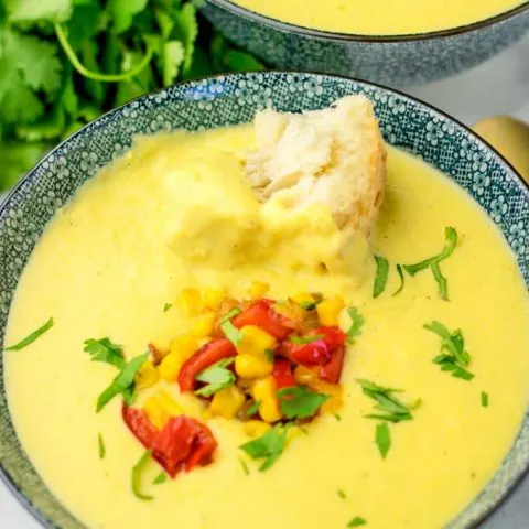 Portion of the corn chowder made in the instant pot with a piece of fresh bread.