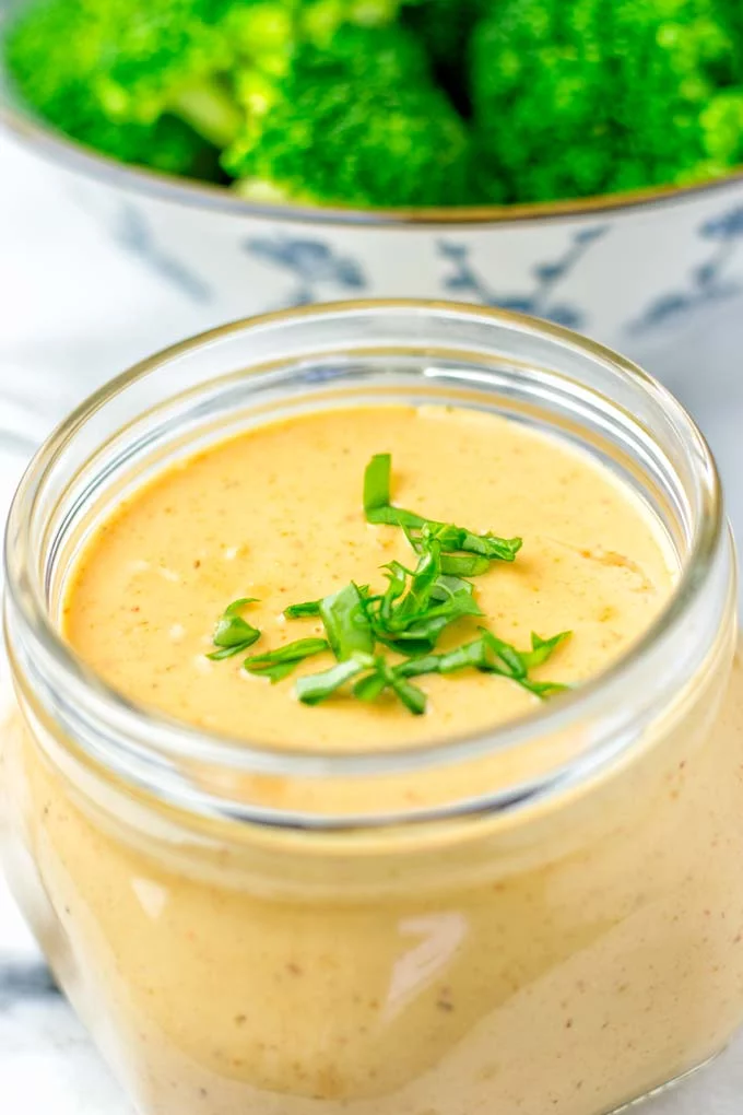 Thai Peanut Sauce in a jar with basil on top. 