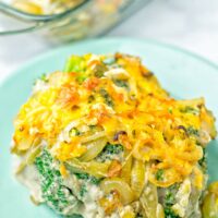 Head on view of the vegan broccoli casserole, showing broccoli, cream of mushroom sauce, fried onions, and crunchy cheese crust