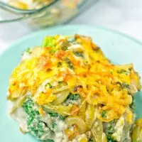 Head on view of the vegan broccoli casserole, showing broccoli, cream of mushroom sauce, fried onions, and crunchy cheese crust
