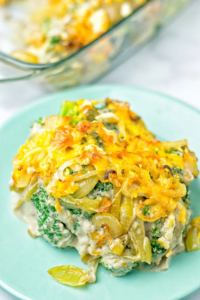 Head on view of the vegan broccoli casserole, showing broccoli, cream of mushroom sauce, fried onions, and crunchy cheese crust