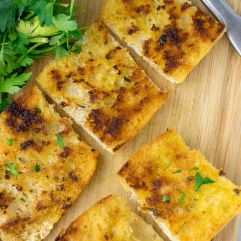 Top view of a plate with slices of Garlic Bread.