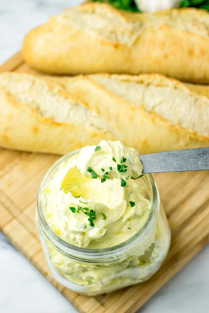 Closeup of vegan garlic butter on a knife ready to be spread on bread.