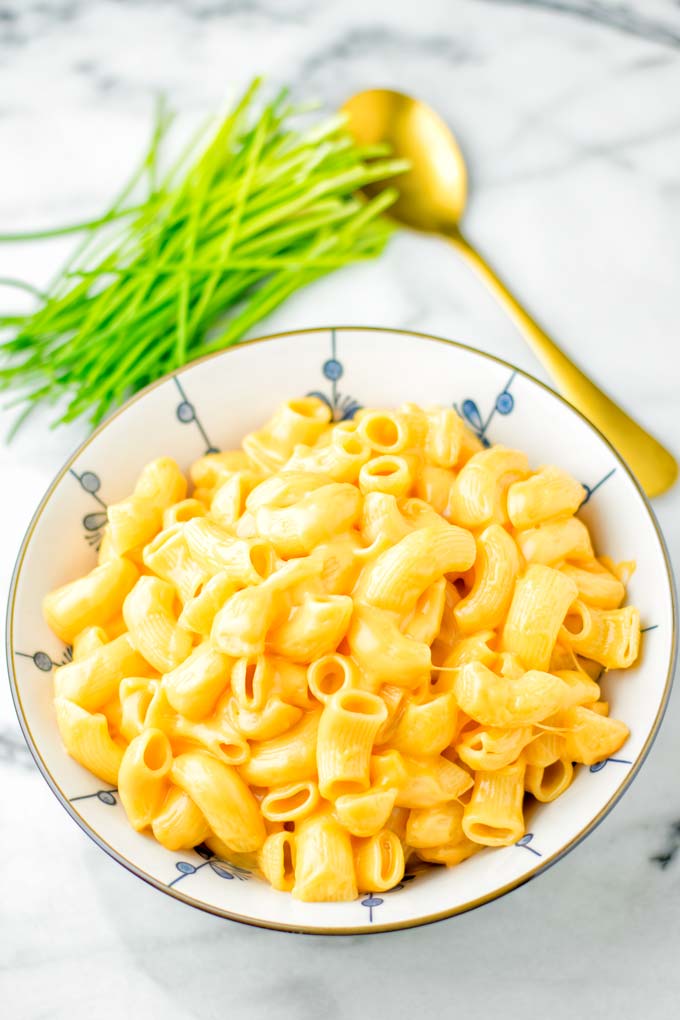 Mac and Cheese from the Instant Pot in a large bowl with a golden spoon in the background.