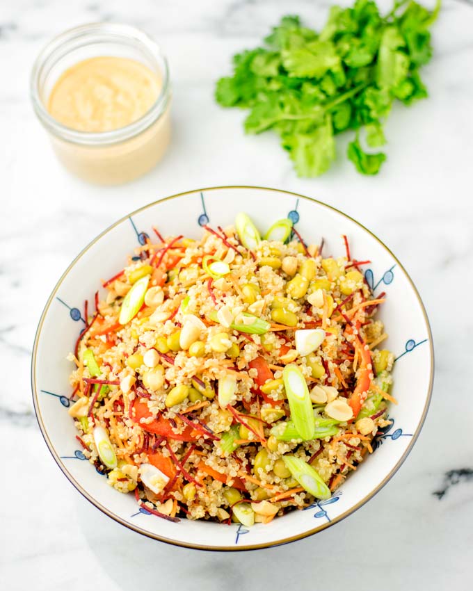 Far shot of the Thai Quinoa Salad with Basil and a jar of Thai Peanut sauce in the background.