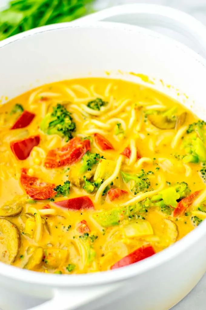 Closeup of coconut curry noodle soup, showing vegetables.