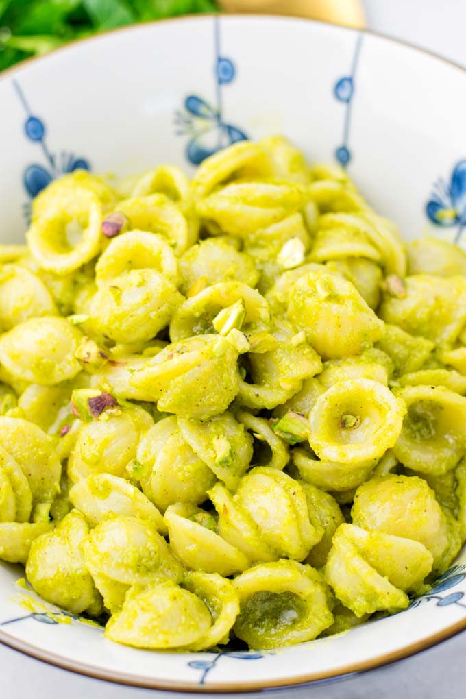 Bowl full of pasta in pistachio pesto.