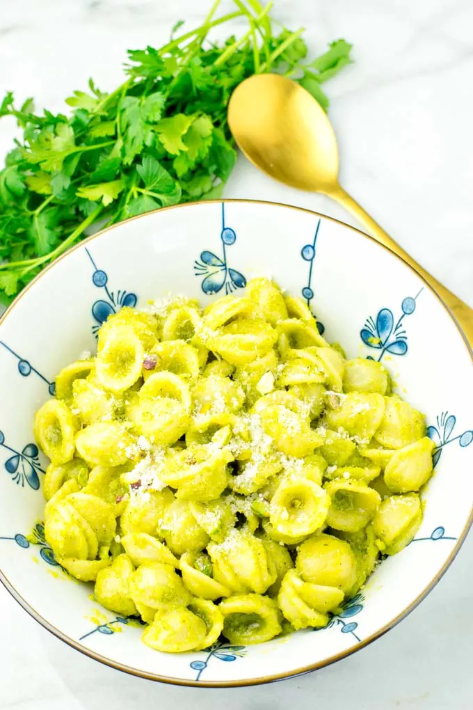 Pesto pasta sprinkled with fresh vegan Parmesan.