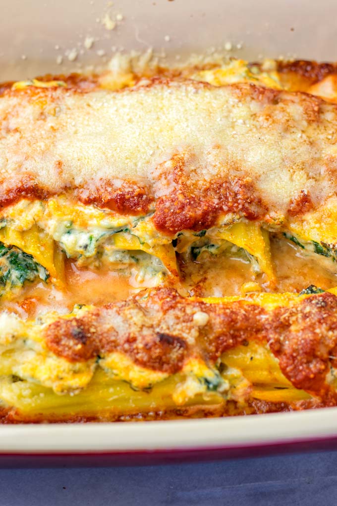 Closeup of the filled Manicotti, covered with vegan Parmesan and baked to perfection.