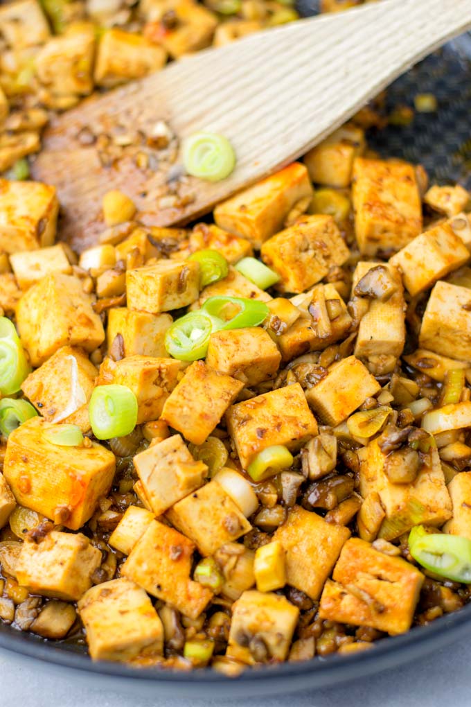 Closeup view of the Mapo Tofu being prepared in a saucepan. 