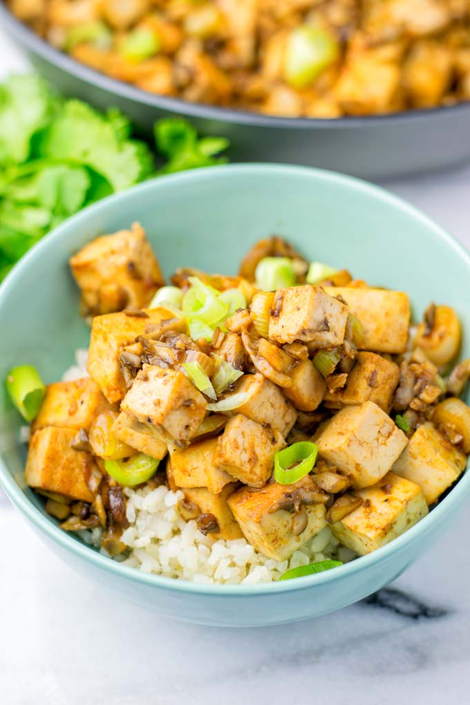 A light green bowl filled with rice and Mapo Tofu.