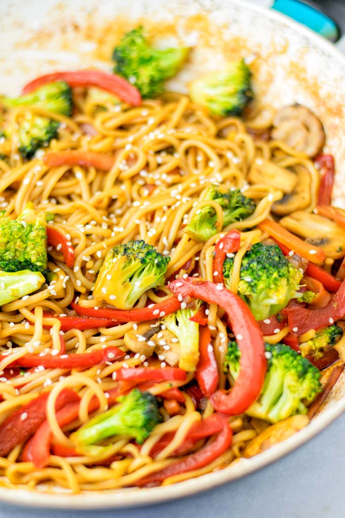 Closeup showing broccoli and bell pepper, covered with sesame seeds.