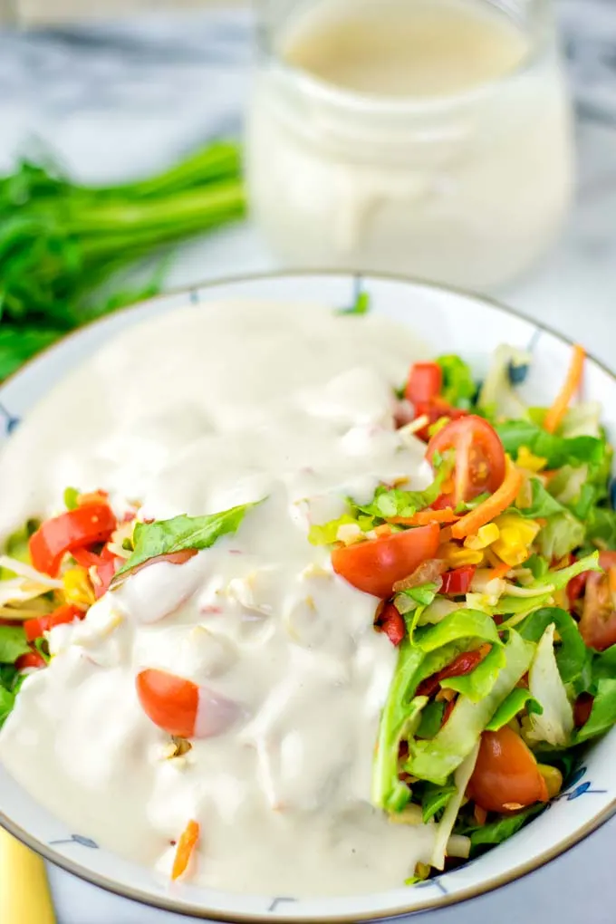 Colorful salad covered in dressing.