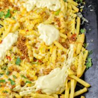 Single sheet pan for the oven, filled with loaded fries.