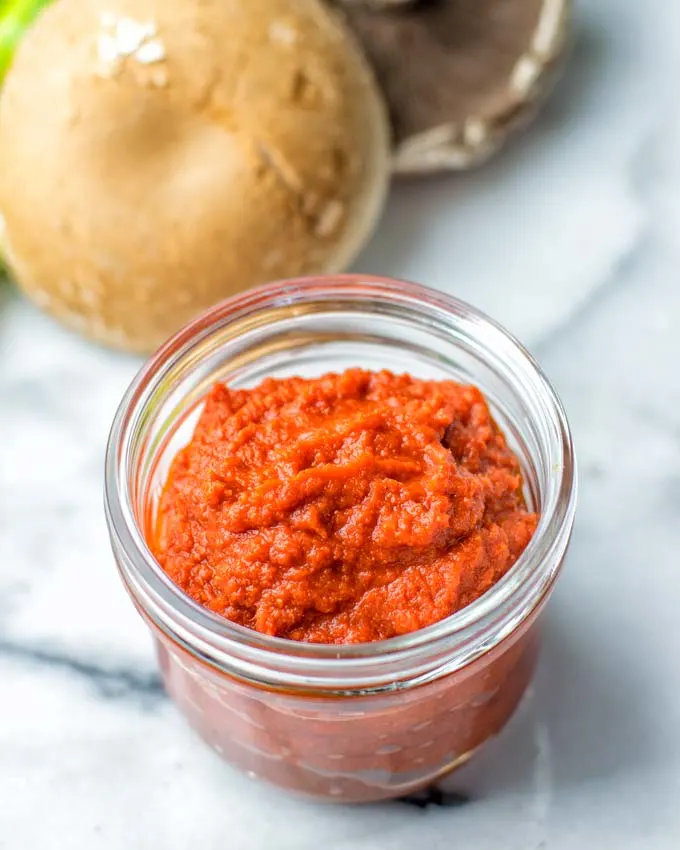 A simple homemade red curry paste in a glass bowl.
