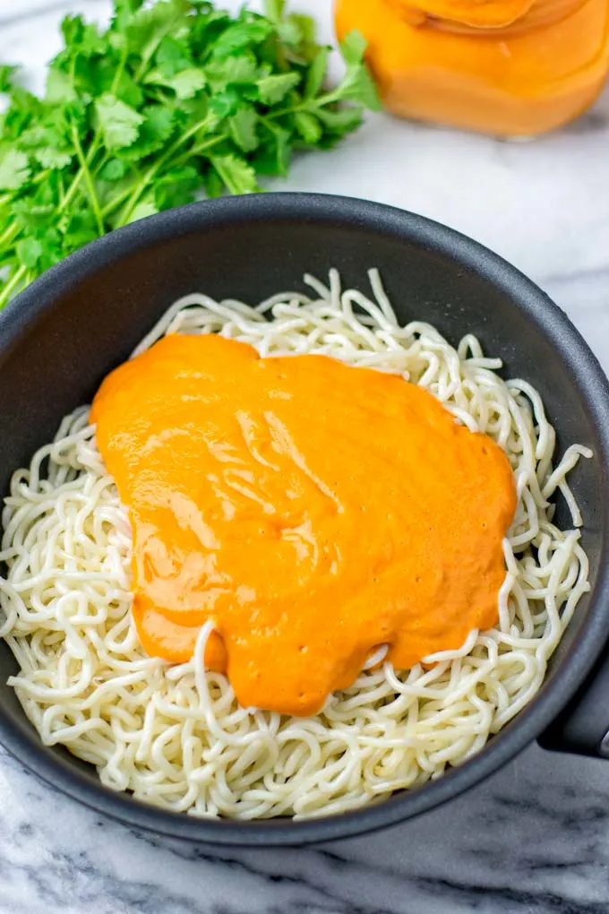 Noodles covered in sauce in a pan.