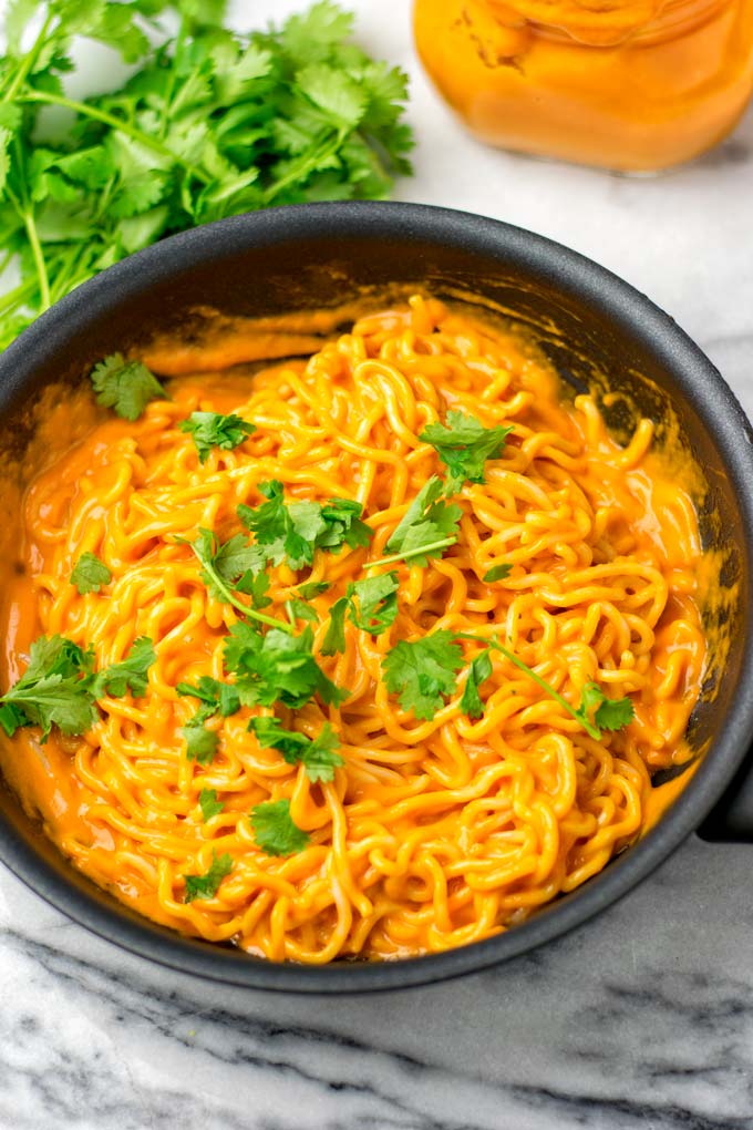 Yum Yum Noodles decorated with cilantro in a sauce pan.