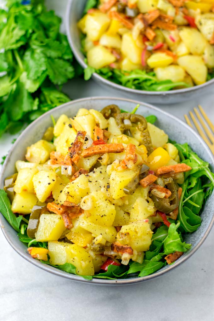 Portion of the prepared salad in a bowl with a second one in the background.