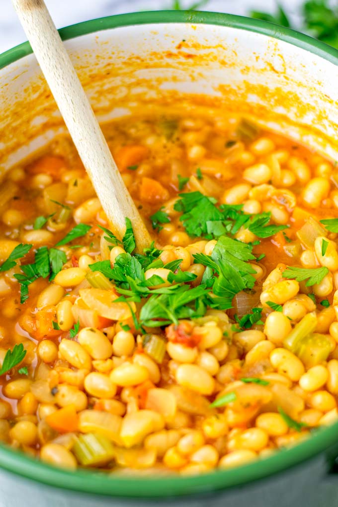 Closeup of the cooked white bean soup, decorated with parsley. 