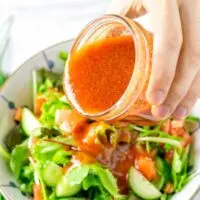 Pouring the Catalina Dressing over fresh salad.