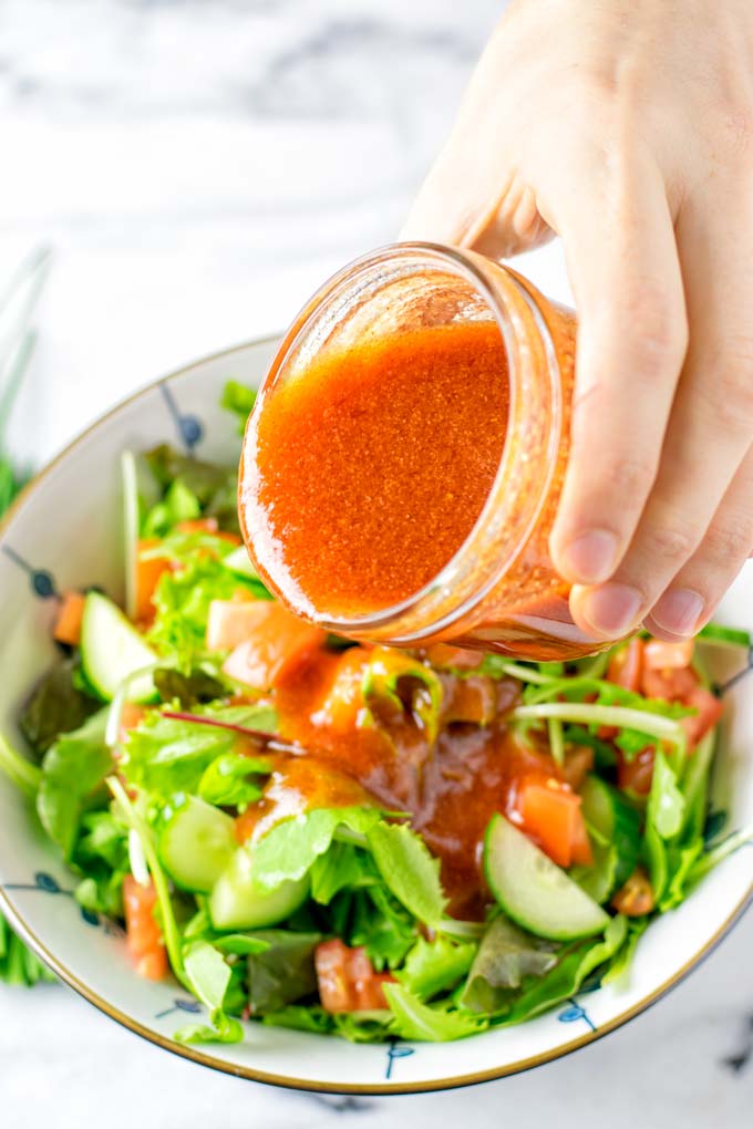 Pouring the Catalina Dressing over fresh salad.