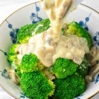 Mushroom Gravy is poured over a bowl of steamed broccoli.