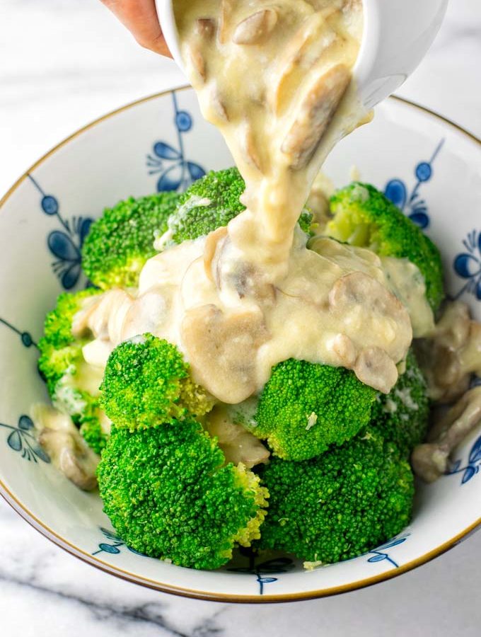 Mushroom Gravy is poured over a bowl of steamed broccoli.