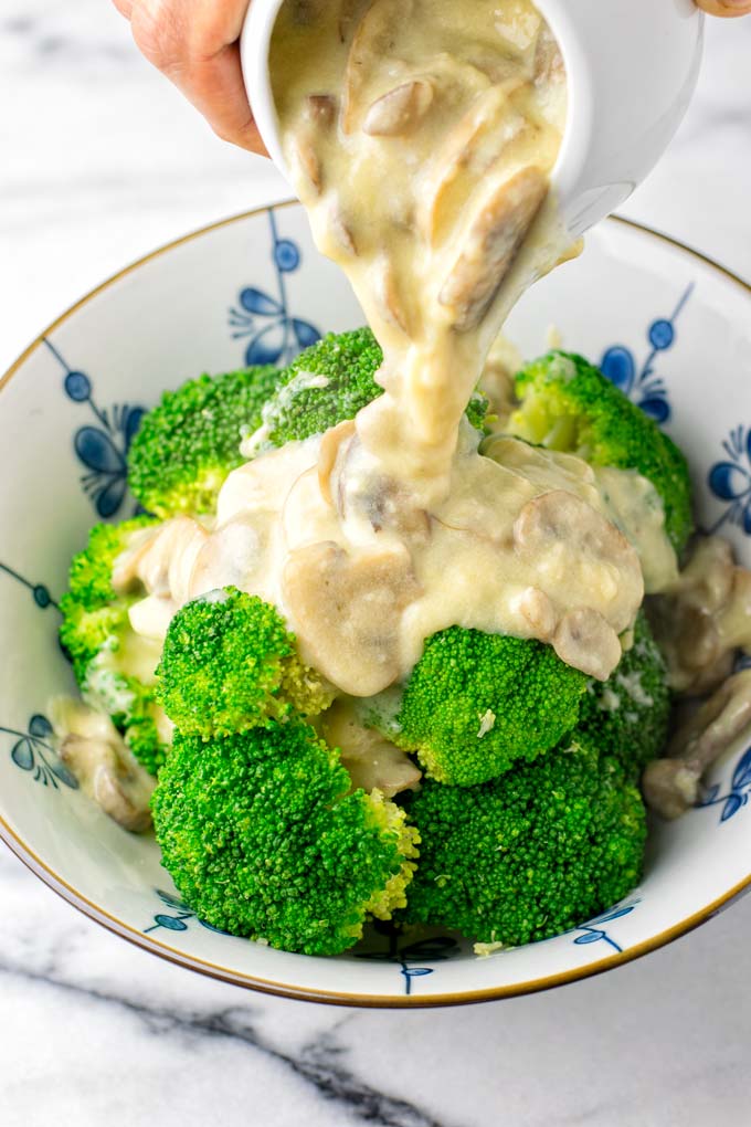 Mushroom Gravy is poured over a bowl of steamed broccoli.