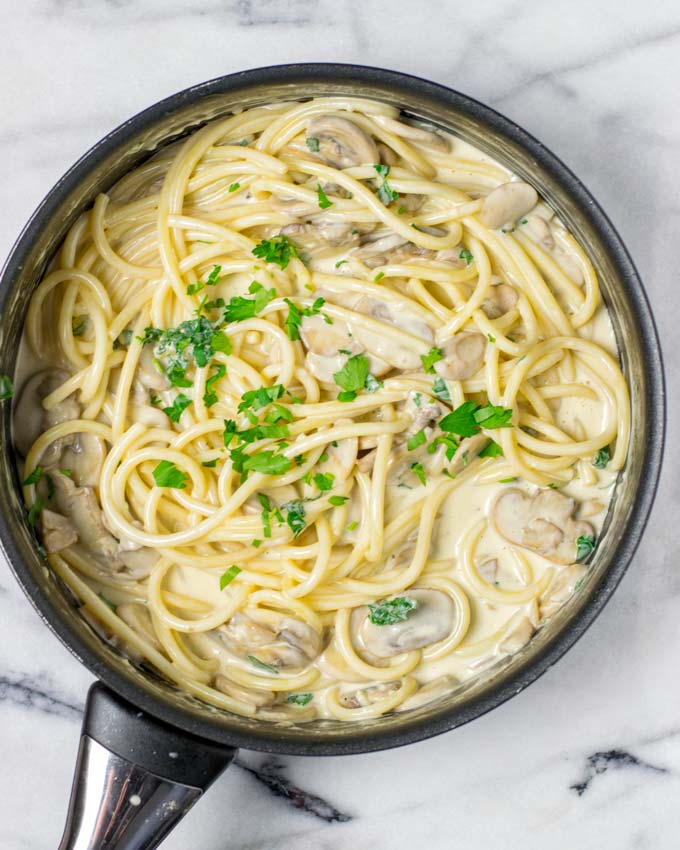 Sauce and noodles in a large casserole, sprinkled with fresh parsley.