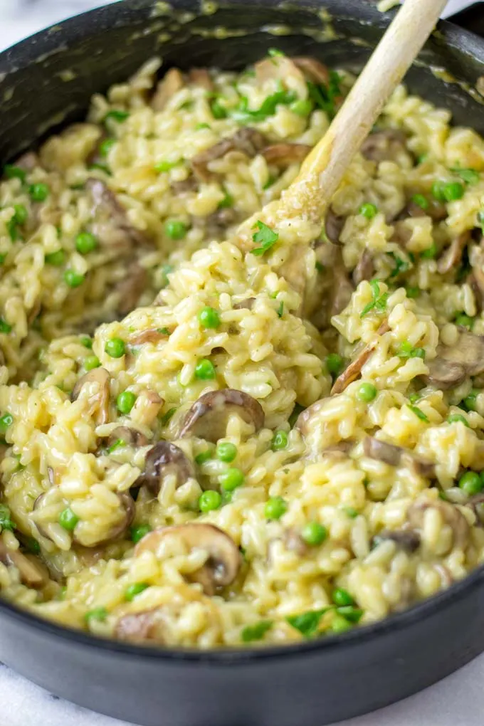 Wooden spoon in the creamy risotto.