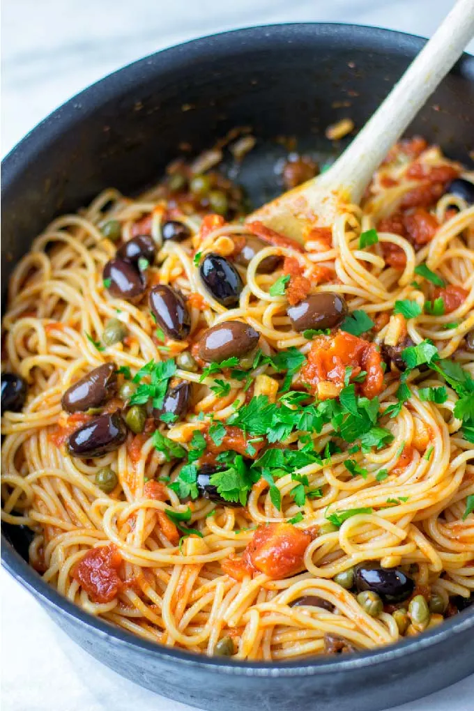 Closeup view of the Puttanesca Sauce mixed with pasta.