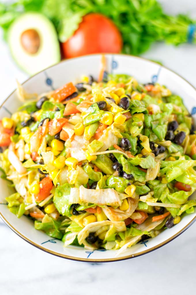 Closeup view showing the lettuce, tomatoes, corn and black beans.