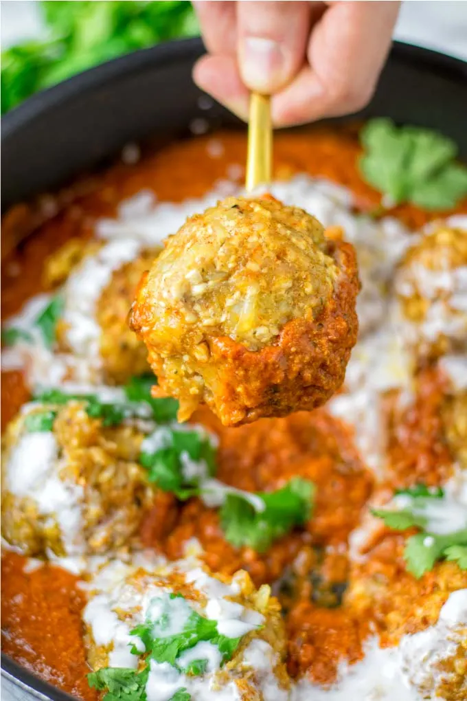 One ball of the Malai Kofta on a golden spoon 